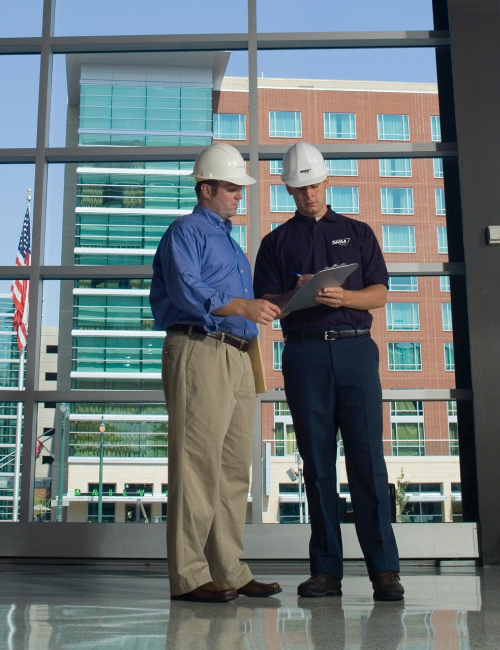 Two men discussing paperwork on the job site.